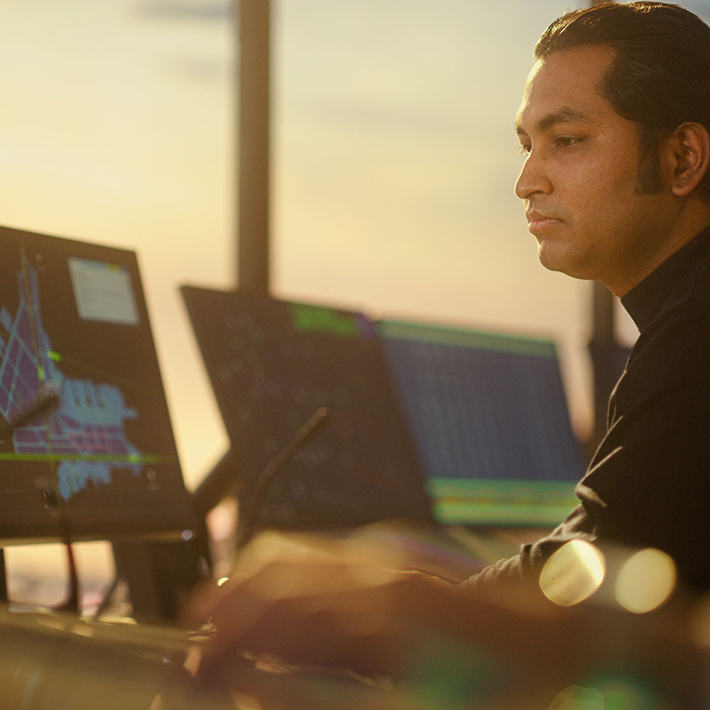 Air traffic controller focused on screens, ensuring safe aircraft operations with high-quality ergonomic chair.